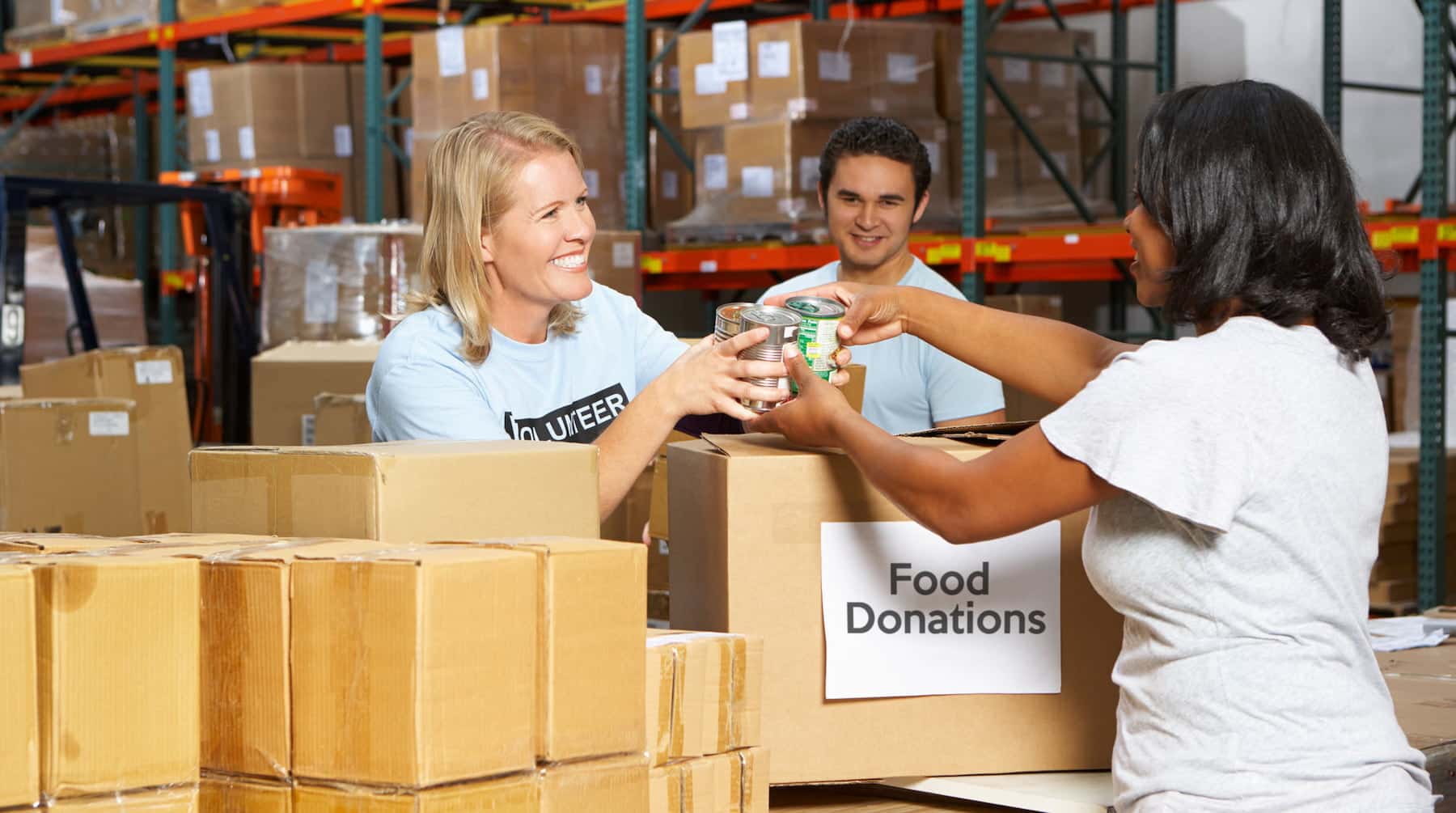 Volunteers passing food donations across a table